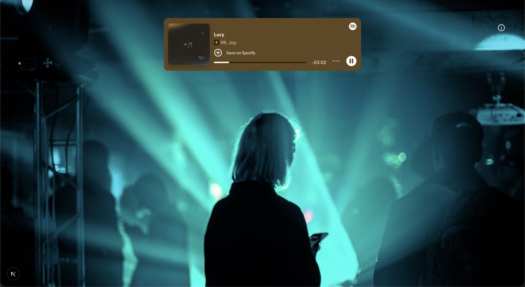 The Music & Imagery player showing Mt. Joy’s “Lucy” playing in a Spotify card over a teal-lit concert photo