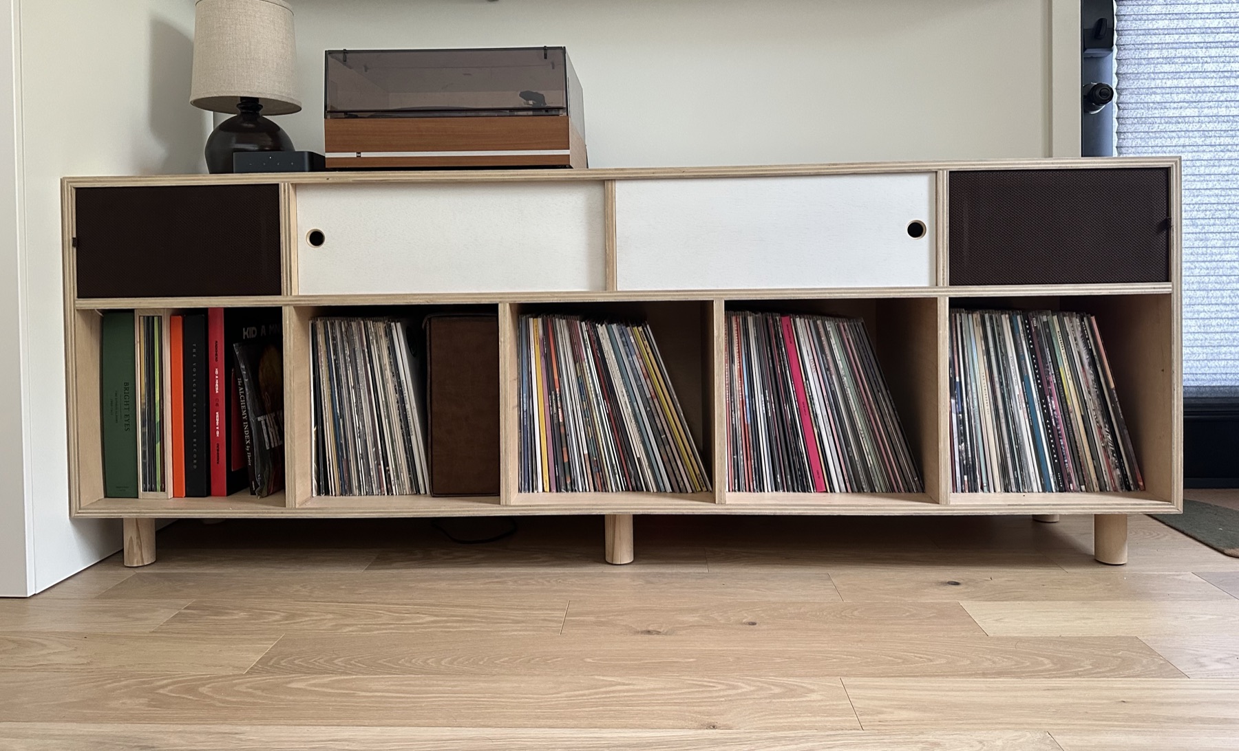 Front view of the record cabinet with its white sliding doors closed over the receiver