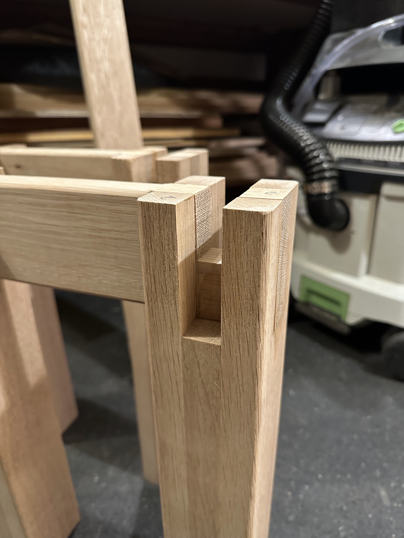 Unfinished table leg in the workshop, with a slot cut into the top to receive the frame